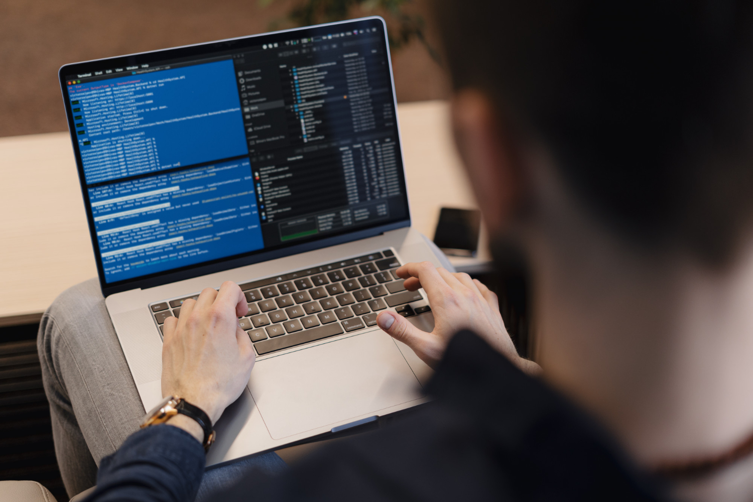 Software engineer debugging code and managing backend services on a high-performance development laptop